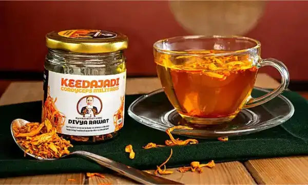 Keedajadi herbal tea jar with golden-orange dried flowers and green label.